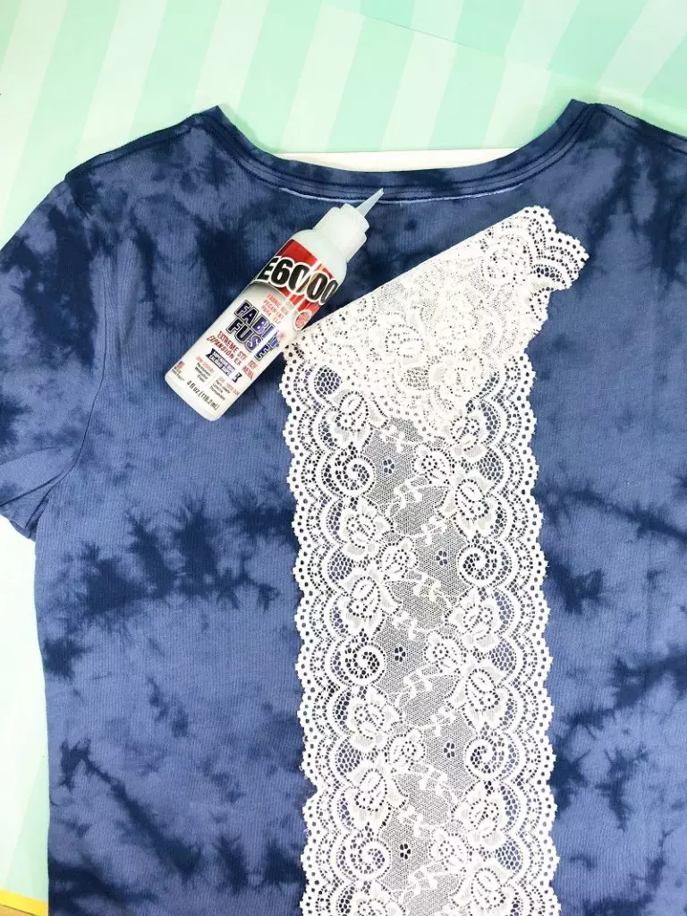 Girl wearing a blue colored tee shirt with white lace trim attached to the back with fabric glue. #creativelybeth #upcycled #clothing #lace #tshirt #teeshirt