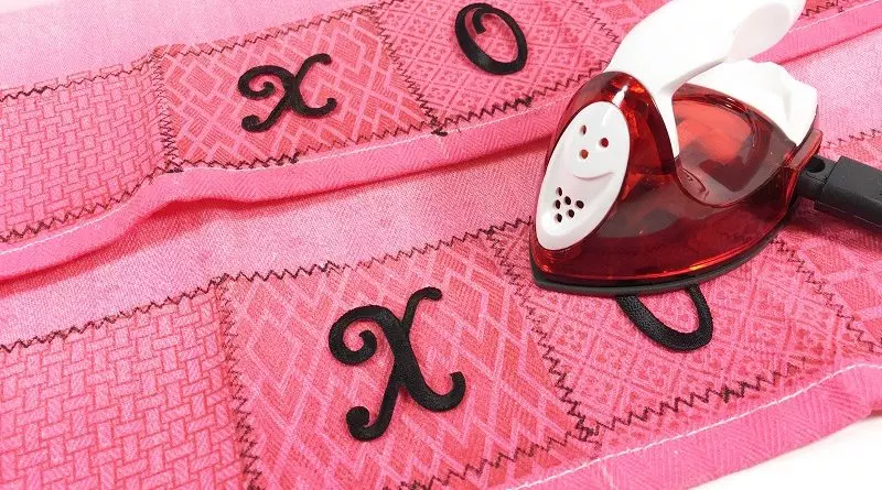 Iron on embroidered letters to spell out a message Hugs and Kisses Kitchen Towels for Valentine's Day Creatively Beth #creativelybeth #valentinesday #crafts #hugsandkisses