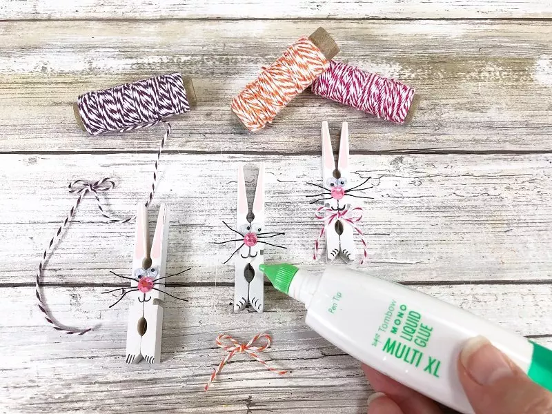 Add a bow from baker's twine to Bunny with glue Creatively Beth #creativelybeth #dollatreecrafts #eastercrafts #bunny #bunnies #clothespincrafts