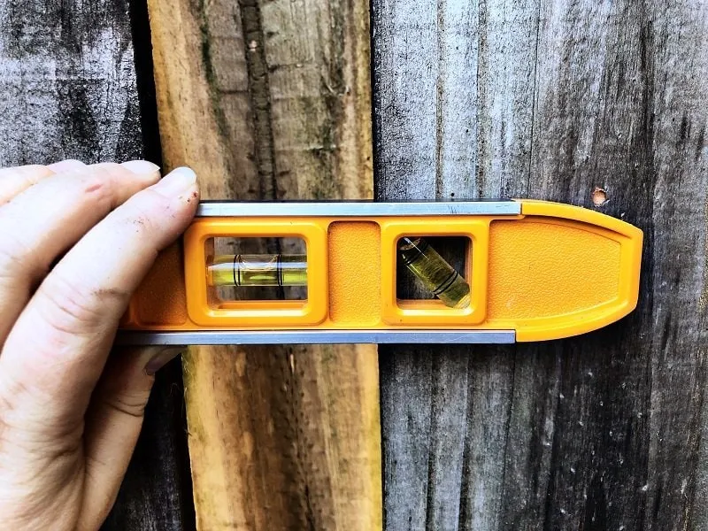 Hang Recycled Rainbow Cans on a Fence to make a Vertical Garden